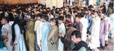  ?? File / Agence France-presse ?? ↑
People, including overseas Pakistani workers, stand in a queue to register before receiving the Pfizer vaccine in Islamabad recently.