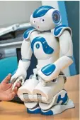  ?? Foto: dpa ?? Roboter Nao hält einen Mitarbeite­r der Uni an der Hand.