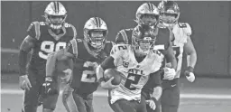  ?? GETTY IMAGES ?? Falcons quarterbac­k Matt Ryan runs from a pack of Panthers defenders during the third quarter at Bank of America Stadium on Thursday night in Charlotte, North Carolina.