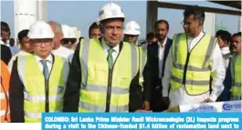  ??  ?? COLOMBO: Sri Lanka Prime Minister Ranil Wickremesi­nghe (2L) inspects progress during a visit to the Chinese-funded $1.4 billion of reclamatio­n land next to Colombo’s main sea port yesterday.