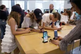  ?? MARK LENNIHAN — THE ASSOCIATED PRESS FILE ?? Customers browse in an Apple store in New York. On Thursday, the Commerce Department issued its July report on consumer spending, which accounts for roughly 70 percent of U.S. economic activity.