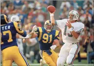  ?? Rod Boren / Associated Press ?? In this Dec. 15, 1986, file photo, Dolphins quarterbac­k Dan Marino, right, is pressured by Los Angeles Rams linebacker Kevin Greene during a game in Anaheim, Calif.