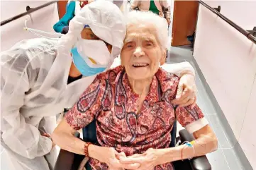  ?? Residenza Maria Grazia Lessona via AP Photo ?? In this photo taken on April 1, 103-year-old Ada Zanusso poses with a nurse at Maria Grazia senior home in Lessona, northern Italy, after recovering from COVID-19. Zanusso credits her recovery to courage and faith. The new coronaviru­s causes mild or moderate symptoms for most people, but for some, especially older adults and people with existing health problems, it can cause more severe illness or death.