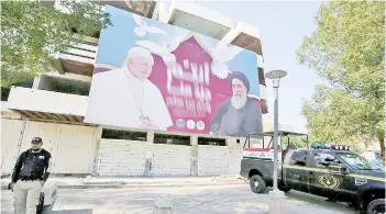  ?? — AFP photo ?? A giant billboard bears portraits of Francis and Sistani in Baghdad ahead of the first-ever papal visit to Iraq, aiming to encourage the dwindling Christian community to remain in their ancient homeland, and broaden his outreach to Islam.