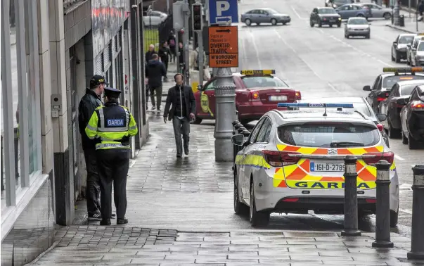  ??  ?? ALERT: Gardai on duty outside the Belmont Apartments in Gardiner Street near where arrests were made and firearms seized. Photo: Tony Gavin