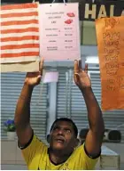  ?? ?? Going up: Osman holding the price tag of imported beef at his stall in George Town, Penang.