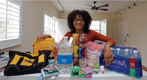  ?? Associated Press ?? above Lexi Montgomery poses with supplies she has purchased in the event of another storm Sept. 29 in Miami Beach, Fla. Hurricane Irma was the first hurricane Montgomery ever experience­d.