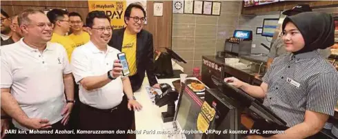  ??  ?? DARI kiri, Mohamed Azahari, Kamaruzzam­an dan Abdul Farid mencuba Maybank QRPay di kaunter KFC, semalam.