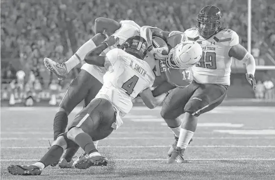  ?? Tim Warner / Getty Images ?? Reggie Hemphill-Mapps of Texas is tackled short of the goal line by Texas Tech’s Desmon Smith during the second quarter of Friday night’s game at Austin.