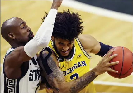  ?? CARLOS OSORIO — THE ASSOCIATED PRESS ?? Michigan forward Isaiah Livers (2) is defended by Michigan State guard Joshua Langford during the first half of Sunday’s game in East Lansing.