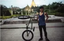  ??  ?? Sai Aung Zaw Myint, 14, young Myanmar stunt biker posing for photograph­s in Yangon. — AFP photos