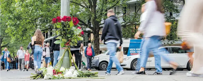  ?? Dpa-BILD: Zinken ?? An einem Ampelmast auf der Tauentzien­straße wurden in Trauer um die getötete Lehrerin und die zahlreiche­n Verletzten Blumen niedergele­gt.