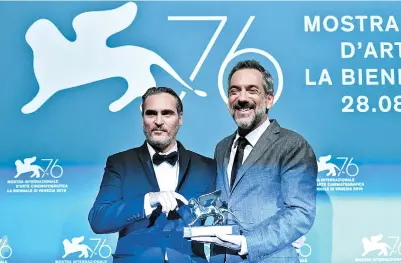  ??  ?? US director Todd Phillips (right) with Joaquin Phoenix, holds the Golden Lion award for Best Film he received for the “Joker” at the 76th Venice Film Festival, on Saturday in Italy. — AFP