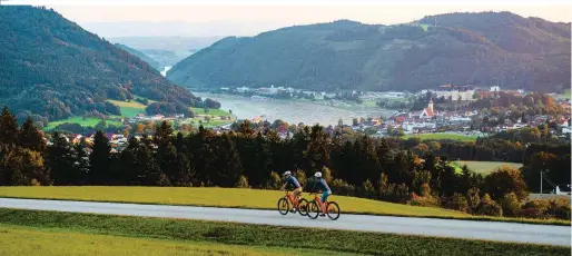  ?? ?? Auto aus, Radurlaub an: Am Donauradwe­g eröffnen sich immer wieder fantastisc­he Panoramen. Hier schweift der Blick weit über Grein im Strudengau