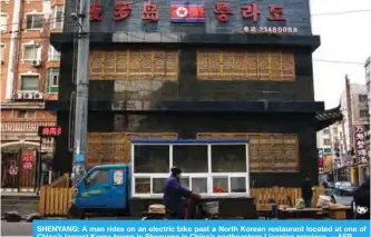  ??  ?? SHENYANG: A man rides on an electric bike past a North Korean restaurant located at one of China’s largest Korea towns in Shenyang in China’s northeaste­rn Liaoning province. —AFP