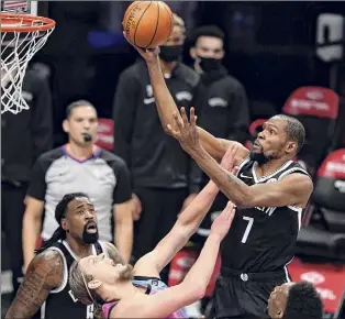  ?? Frank Franklin II / Associated Press ?? Miami’s Kelly Olynyk, center, takes a charge from Brooklyn’s Kevin Durant during the first half of their game on Saturday. Durant had 31 points in the game.