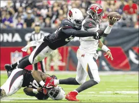  ?? AP ?? Bucs QB Jameis Winston (right) suffered a sprained AC joint in his passing shoulder on this play Sunday at Arizona. He hasn’t been ruled out for this week’s game at Buffalo.