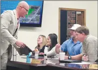  ?? (NWA Democrat-Gazette/Lynn Kutter) ?? Prairie Grove Mayor David Faulk uses his tablet Feb. 26 to show City Council members Chris Powell and Doug Stumbaugh a parking lot downtown that the city is considerin­g buying.