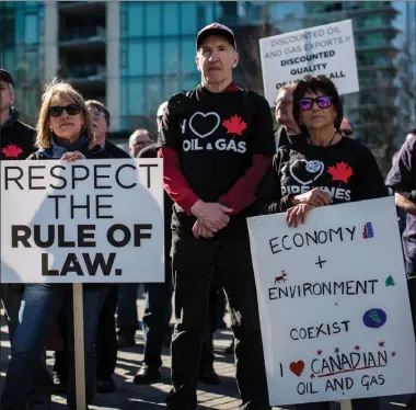  ?? The Canadian Press ?? People hold signs while listening during a rally in support of the Kinder Morgan Trans Mountain pipeline expansion in Vancouver on Saturday.