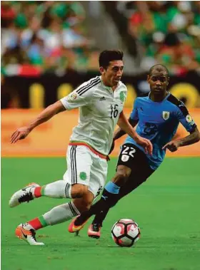  ?? AFP/Getty Images ?? Héctor Herrera (izq.), autor de un gol, trata de escapar de la marca del uruguayo Diego Rolán durante el importante triunfo de México por 3-1 el domingo en Glendale, Arizona.