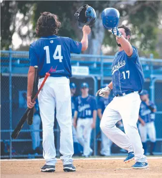  ?? Picture: JOHN GASS ?? Surfers’ Scott Hillier (right) is greeted after his homer by a teammate at the plate.