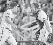  ?? Mike Theiler / Associated Press ?? Virginia reliever Josh Sborz, left, and catcher Matt Thaiss weren’t cavalier about defeating Florida on Saturday to advance to the finals in Omaha.