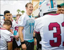  ?? ALLEN EYESTONE / THE PALM BEACH POST ?? Dolphins quarterbac­k Ryan Tannehill (17) lets a player from Marjory Stoneman Douglas High School try on his helmet.