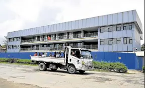  ?? —PHOTOS BY AFP ?? BEIJING’S PRESENCE A truck with several passengers makes its way past the Chinese embassy in Honiara, capital city of Solomon Islands, on April 16.