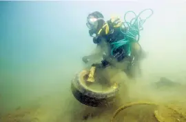  ??  ?? DUMPING GROUND: A diver hauls old tyres and other pollution from a cove near Port-Miou in Cassis, France, this year