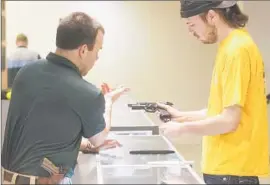  ?? Michael Ainsworth
Dallas Morning News ?? INSTRUCTOR Mike Campbell shows Dwayne Reese a gun at a gun club in Frisco, Texas. The state is moving to allow guns to be carried under more circumstan­ces.