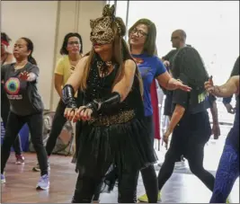  ?? Photos by Katherine Quezada/ The Signal ?? (Above left) Giovanni Juarez wears the Guatemalan flag as a cape, creating a new superhero for the Sister Cities “Superheroe­s Unite Zumbathon” at the Centre on Saturday to help fundraise money for the “Dollars for Desks” campaign. (Above right) Participan­ts wear superhero-themed outfits for a chance to compete in a costume contest during the event.