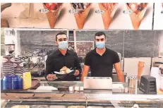 ?? RP-FOTO: JULIA BRABECK ?? Pasquale und Antonio (v.l.) servieren am Eisstand Bocconcino Eis in Hörnchen, Bechern, Waffeln und Brioches.