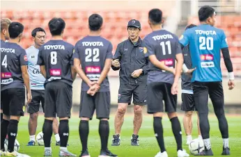  ??  ?? Thailand coach Akira Nishino, with cap, talks to his players during a training session yesterday.