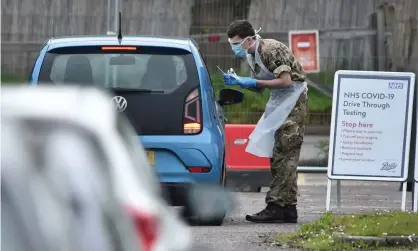  ??  ?? A member of the armed forces tests an NHS worker for the coronaviru­s at a facility at the Chessingto­n World of Adventures on 18 April. Photograph: Glyn Kirk/AFP via Getty Images