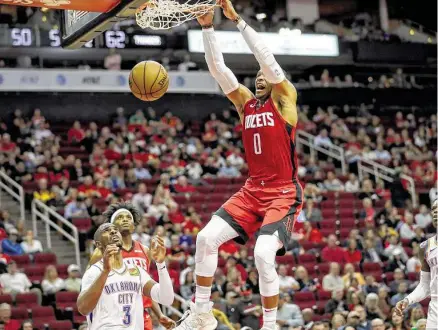  ?? Jon Shapley / Staff photograph­er ?? Russell Westbrook soars over Chris Paul as the main components in a summer blockbuste­r share the stage Monday night.