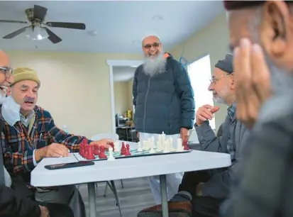  ?? KARL MERTON FERRON/BALTIMORE SUN ?? Shabbir Kapadia, from left, listens as Jalal Akbar shares chess rules and strategy while Eliyas Valiullah, Mohammad Saleem and Malik Latif watch. They take part in the Golden Age Village on the grounds of the Islamic Society of Baltimore.