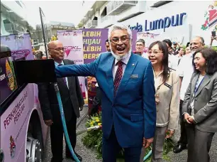  ??  ?? Greener fuel: Khalid is all smiles as he fills up a GoKL bus with B10 biodiesel. Looking on are Kok (second from right) and Land Public Transport Commission chief operating officer Qamar Wan Noor (right).