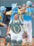  ?? TOM E. PUSKAR — THE ASSOCIATED PRESS ?? Hawaii’s Mana Lau Kong (19) is mobbed by teammates after hitting the first pitch of Sunday’s game for a home run.