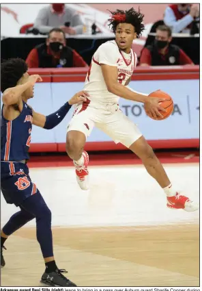  ?? (NWA Democrat-Gazette/Andy Shupe) ?? Arkansas guard Desi Sills (right) leaps to bring in a pass over Auburn guard Sharife Cooper during the Razorbacks’ victory Wednesday night at Walton Arena in Fayettevil­le. Sills led Arkansas with 22 points. More photos available at arkansason­line.com/121uaau.