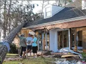  ?? RUSS BYNUM / ASSOCIATED PRESS ?? Rex Buzzett (far left), his son Josh and neighbor Hilda Duren stand Thursday outside the Buzzetts’ home in Port St. Joe, Fla., gutted by Michael.