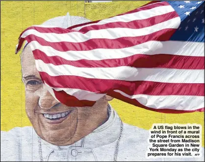  ?? AFP ?? A US flag blows in the wind in front of a mural of Pope Francis across the street from Madison
Square Garden in New York Monday as the city prepares for his visit.