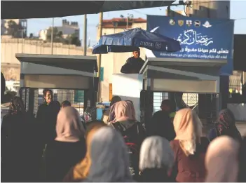  ??  ?? Palestinia­ns make their way through an Israeli checkpoint to attend the first Friday prayer of the holy fasting month of Ramadan in Jerusalem’s Al-Aqsa mosque, near Ramallah in the occupied West Bank. — Reuters photo