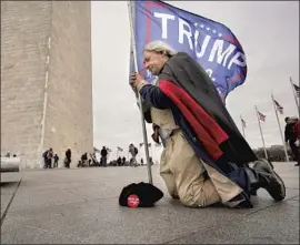  ?? Carolyn Kaster Associated Press ?? A TRUMP BACKER dressed as George Washington prays Jan. 6 by the Washington Monument. Many in the violent mob that day professed to be Christians.