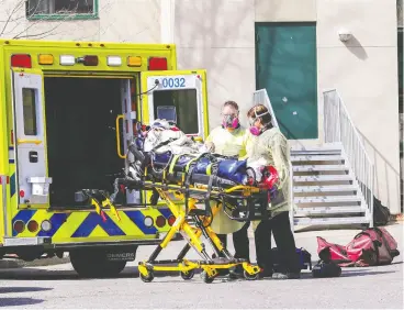  ?? John Mahoney / Postmedia News ?? Paramedics wheel a resident out of CHSLD Herron in Dorval, west of Montreal on Wednesday. The home is struggling with a staff shortage during a COVID-19 outbreak.