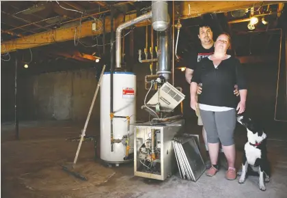  ?? GREG HALINDA/ THE CANADIAN PRESS ?? Homeowners Cora and Alec Dion stand in the `naked' basement of their home in Fort Mcmurray. More than seven months ago, the Dions were among 13,000 residents forced to flee the city when ice jams led to major flooding.