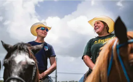  ?? Marie D. De Jesús / Houston Chronicle ?? Wesley Willoughby and Kristi Helton of the Galveston County Mounted Posse watch the hundreds gathered Sunday for the Santa Fe High School’s Class of 2008 reunion fundraisin­g event, which benefited Santa Fe shooting victims and families.