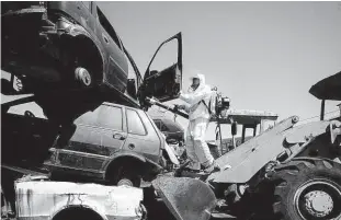  ?? Zanone Fraissat/folhapress ?? Agente da Secretaria Municipal da Saúde combate larvas do mosquito da dengue em pátio de carros abandonado­s na zona norte de São Paulo