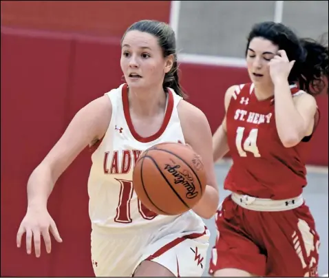  ?? Photo by John Zwez ?? Allie Wilson of Wapakoneta dribbles the ball as she is trailed by Claire Wendel of St. Henry. Wapakoneta won the contest, which was its season opener. See more photos at wapakdaily­news. com.