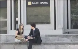  ?? LUCÍA SÁNCHEZ ?? Dos jóvenes conversan junto a una sucursal de Banco Madrid.