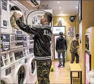  ?? The New York Times/LAM YIK FEI ?? A customer collects clothes at a laundry shop in Hong Kong late last month.